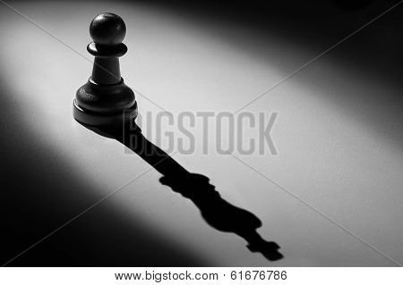 Chess Pawn Standing In A Spotlight That Make A Shadow Of King