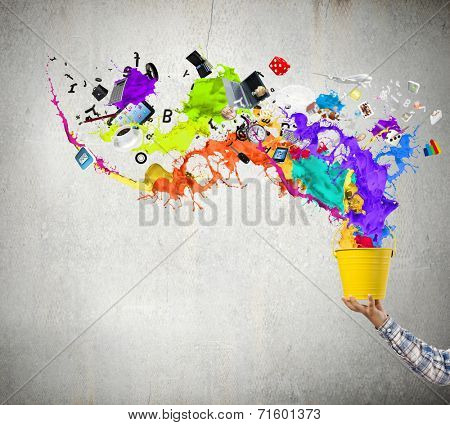 Close up of hand splashing colorful paint from bucket