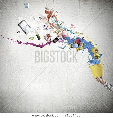 Close up of hand splashing colorful paint from bucket