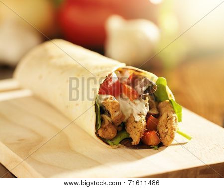 chicken wrap in tortilla with sauce and mesclun mix