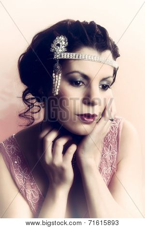 Closeup in vintage colors of a 1920s style young woman with diamond headdress and flapper dress