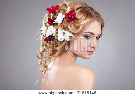 Beautiful girl, isolated on a light - grey background with varicoloured flowers in hairs, emotions, cosmetics