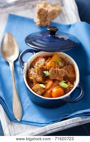 beef stew with potato and carrot in blue pot