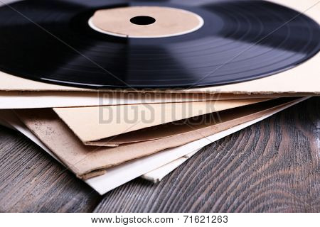 Vinyl records records and paper covers on wooden background