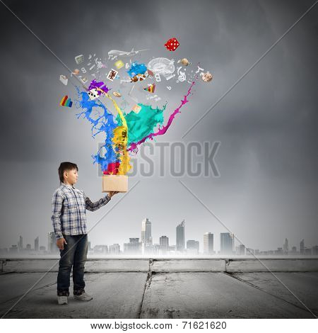 Young boy splashing colorful paint from bucket
