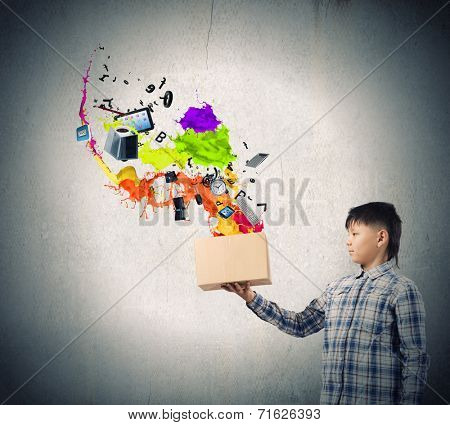 Young boy splashing colorful paint from carton box
