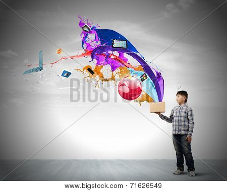 Young boy splashing colorful paint from bucket
