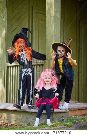 Group of Halloween girls posing on the porch of dilapidated house