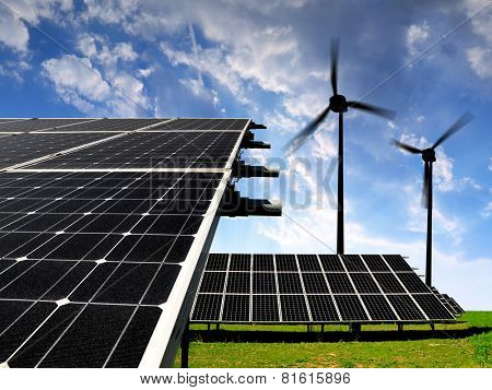 Solar energy panels with wind turbines in the setting sun 