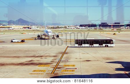 Airplane in the airstrip and bus carrying passengers