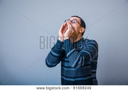 male of European appearance brunet screams put hands to his