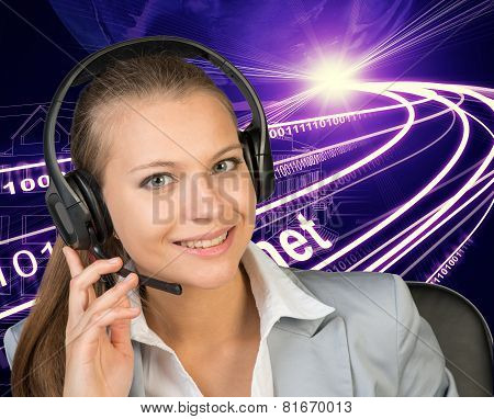 Closeup of businesswoman in headset, wire-frame building with light as backfrop