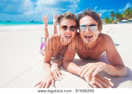 portrait of happy young couple with suncream dots at beac