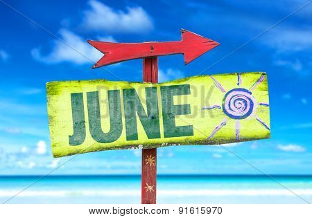 June direction sign with beach background