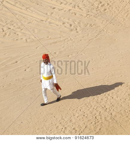 Rajasthani Man With Bright Red Turban And Bushy Mustache Walks Over The Sandy Area In The Desert Hot