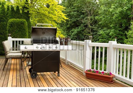 Open Bbq Cooker And Bottled Beer On Outdoor Cedar Patio