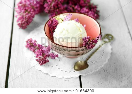 Beautiful composition with tasty ice cream and lilac flowers