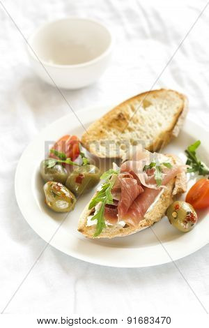 toast with ham, olives, tomatoes and arugula