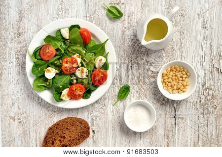 Fresh Salad With Cherry Tomatoes, Mozzarella And Spinach On A White Wooden Surface