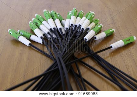 A group head connector fiber optic green color on brown table.Fiber Optics connectors. Internet Serv