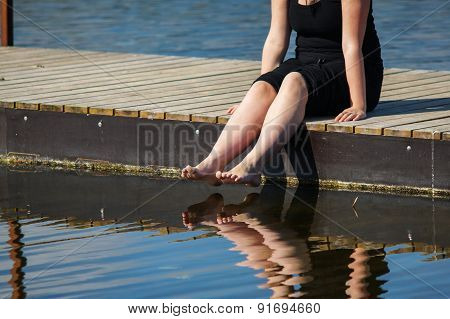 Young Lady Sitting On The Jetty