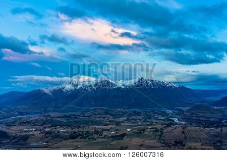 Mountain valley aerial view at dusk. Coronet peak view of Arrowtown village and valley. Otago New Zealand. Winter landscape at sunset