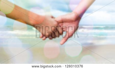 sweet dreamy and de-focused photo ; two person holding by hands against the sea