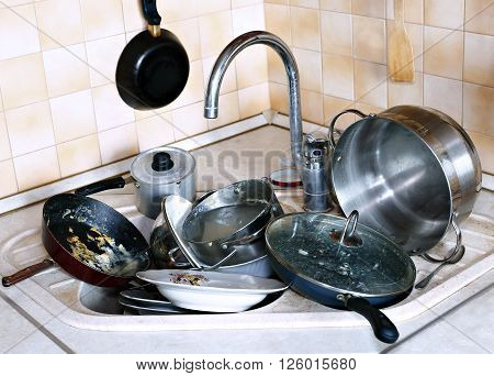 Many of dirty dishes in the sink in the kitchen