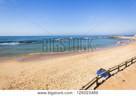 Beach ocean blue water rock tidal pool with holiday bathers swimming coastline landscape.