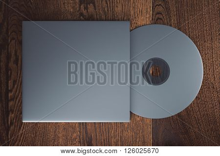 Topview of blank grey compact disk with cover on wooden table. Mock up 3D Rendering