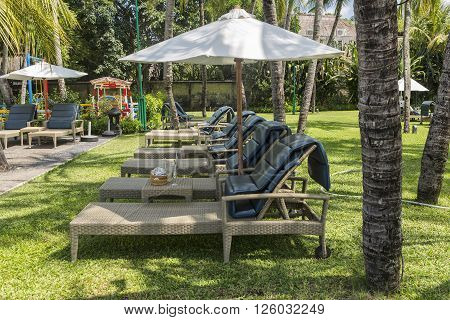 KUTA, BALI - MARCH 3, 2016: Kuta Beach palm coat luxury resort with swimming pool and sunbeds. Bali Indonesia.