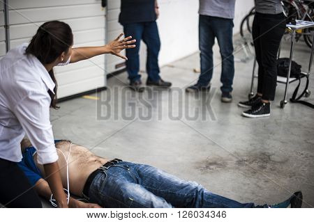 rescuer assisting an unconscious man with defibrillation