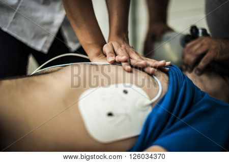 Rescuers assisting an unconscious man with cardiac resuscitation