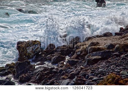 Powerful sparkling waves smashing over the rocks