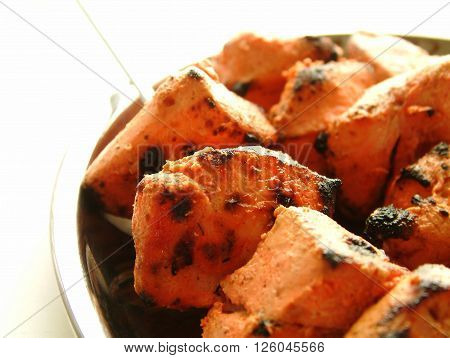 Indian Chicken Tikka Kebab Flame Grilled on rustic background