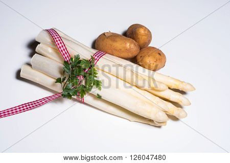 fresh white asparagus with checkered red white rope