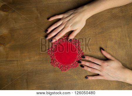 Hand-Knitted linen table napkin handmade on wood background with woman hands