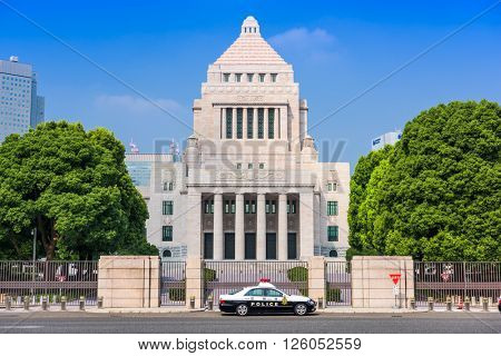 TOKYO, JAPAN - JULY 31 2015: Officers sit in a police cruiser below The National Diet Building of Japan.