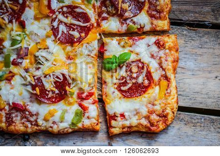 Square Pepperoni Pizza On Rustic Wooden Background