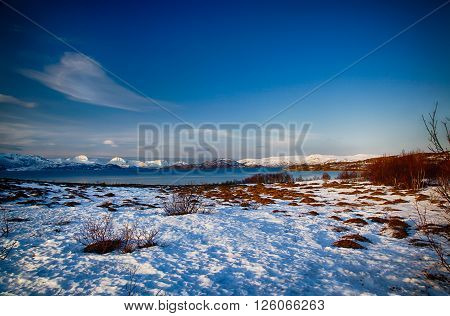 Isolated home and beach on a snowy lake