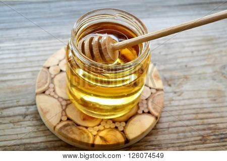Golden honey with honeystick. cinnamon and anise stars on wooden table