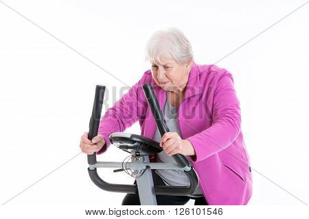 gray-haired female senior with thumb up train with fitness machine