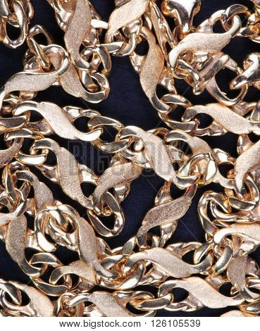 image of many yellow Gold Chain on black fabric
