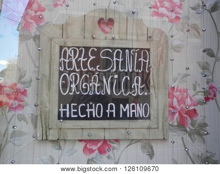 Beautifully painted iwooden sign reflecting in window in Madrid Street