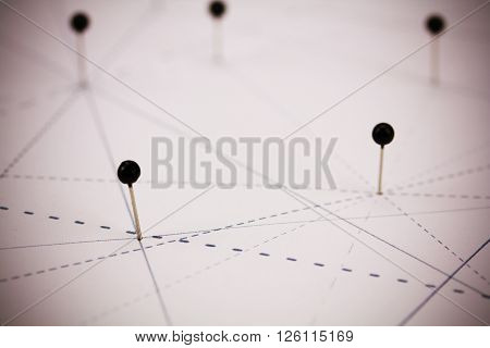 Black Pins In Paper Linked By Lines