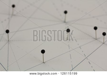 Black Pins In Paper Linked By Lines
