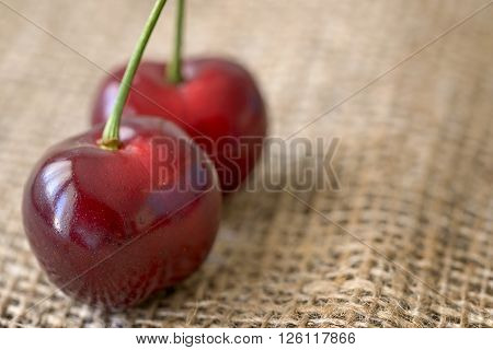 macro two red cherry fruit on jute