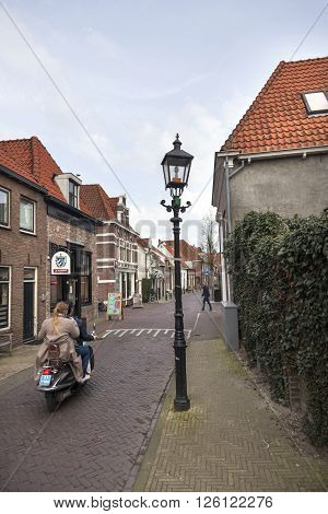 harderwijk, netherlands, 1 april 2016: scooter on old narrow street in old dutch town of harderwijk