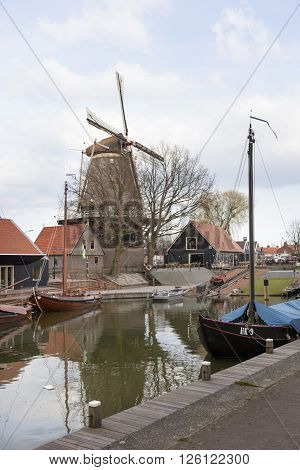 harderwijk, netherlands, 1 april 2016: old harbor in dutch town of harderwijk with windmill De Hoop in the background
