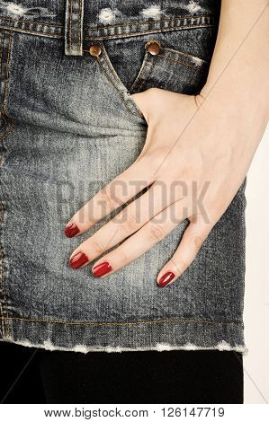  Glamorous girl wears jeans skirt and hand with fashion red nail polish 